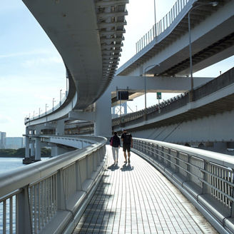 Two people walking on a bridge