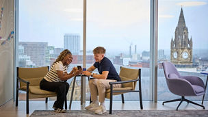 Two people in conversation whilst sat on a sofa