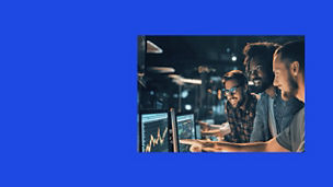 Team working together at computer monitors displaying data charts