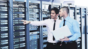 Two men in conversation looking at server