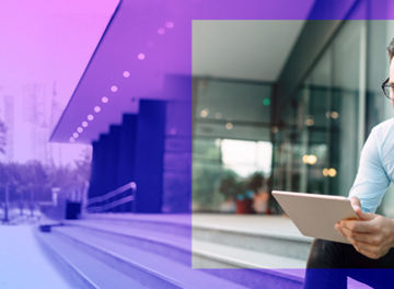 Happy and confident businessman using tablet on office stairs