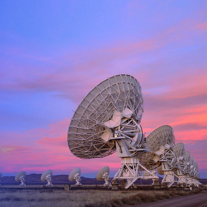 Telecommunications satellite dishes at sunset banner