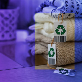 Kleidungsstücke mit Recyclingsymbol auf einem Tisch