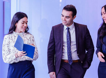 Three colleagues discussing work while walking