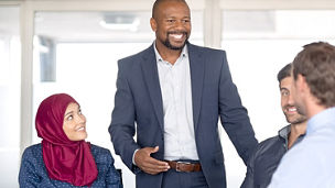Three collegues sitting one standing