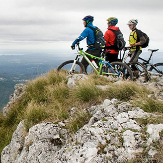 traja cyklisti na skale