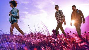three friends walking on grass