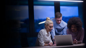 Three people discussing something on the laptop