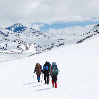 three-people-doing-mountain-hiking-in-snow