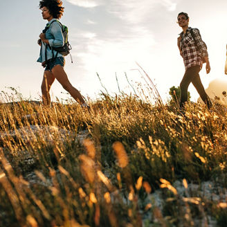 Three people walking on grass