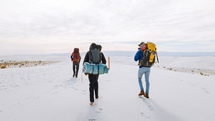 Three people walking on snow