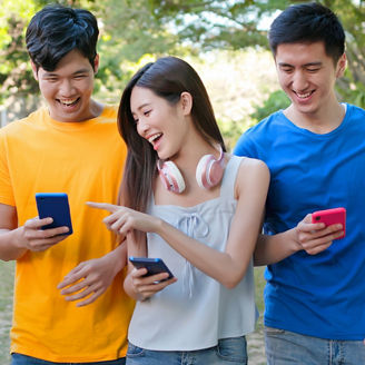 Three teens with phones smiling