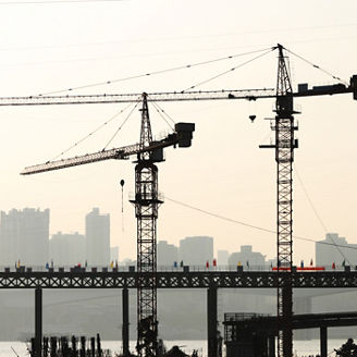 The tower crane is working,there are some characters on the bridge,it's aphorism,no copyright,the mean is keeping safety in production..