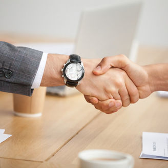 Close up view of handshake, two businessmen in suits shaking hands as concept of trust, good partnership deal, signing contract agreement at meeting, gratitude for help support in business