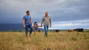 Farmer family walking on a cattle or livestock farm teaching and learning together. Generations of a happy father, grandfather and grandchild bonding on sustainability agriculture land.