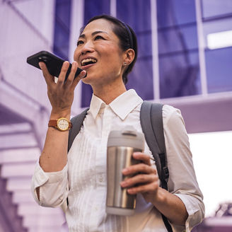 Mature japanese business woman record voice mail or voice recognition on mobile phone in front of modern buildings before work; Shutterstock ID 2517747523; purchase_order: advisory assurance marketing team; job: anne rouschop; client: ai campagne