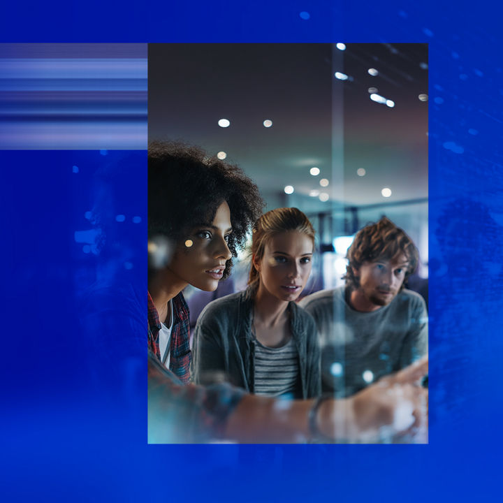 Colleagues discussing work, gathered around a screen