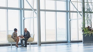 two businesspeople sitting and discussing in office