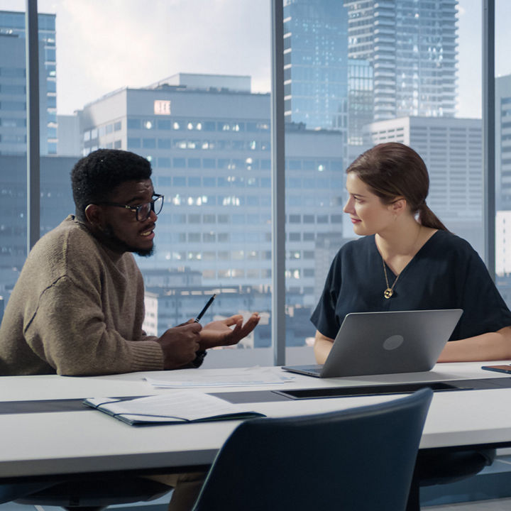 Two coworkers having discussion in office