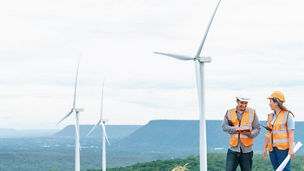 Two engineers standing near windmill