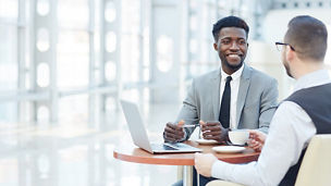 Two people having a discussion whilst sat at a round table