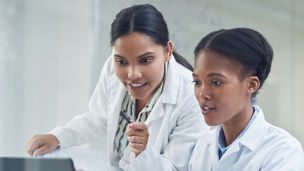 Two ladies in labcoats working