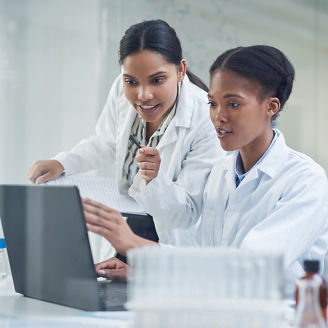 Two ladies in labcoats working