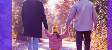 Two men and a girl walking holding hands banner