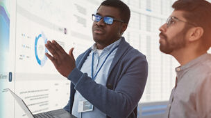 Two men looking at digital dashboards