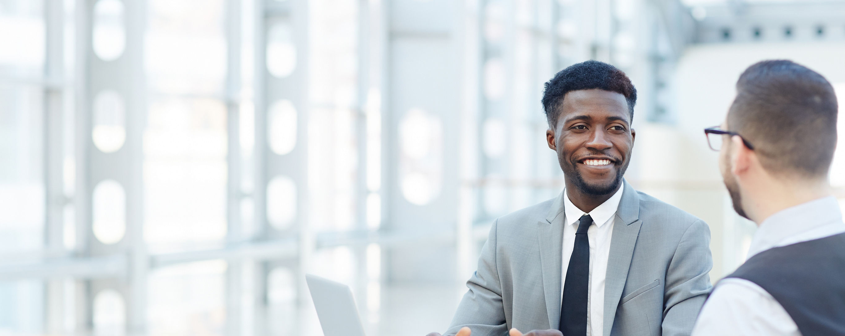 Portrait of successful African-American businessman smiling during meeting with colleague at coffee break