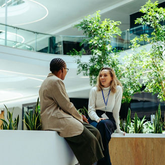 Employees collaborating in a modern office space with indoor greenery.