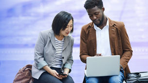 two people looking at laptop banner