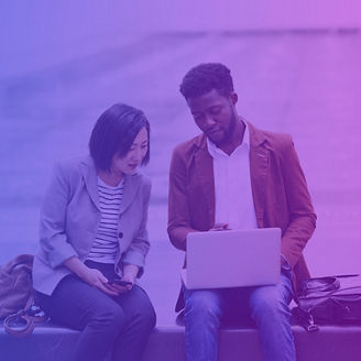 Two people using a laptop in the city