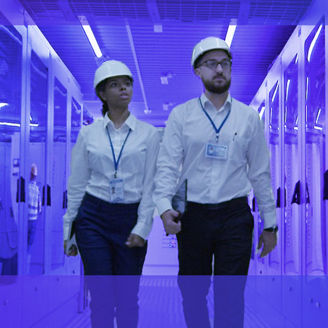 Twee zakenpartners lopen met een helm op door een gang