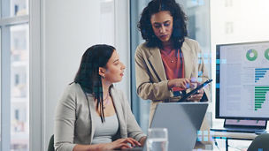 Two women in an office looking at tablet