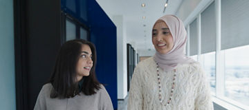 Two women talking while walking