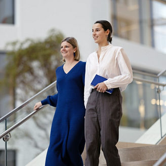 Two women walking down a staircase