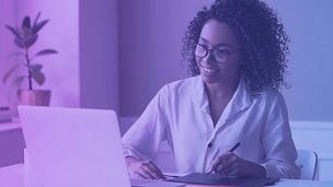 Frau mit Brille und Locken am Laptop sitzend