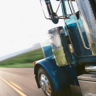 Semi-truck on highway, view from behind cab (blurred motion)
