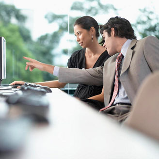 Businesswoman and businessman working on computer
