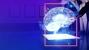 Representação holográfica de um cérebro digital enquanto duas pessoas observam e interagem com a projeção.