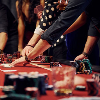 People in elegant clothes standing and playing poker in casino together.
