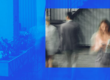 A blurred image of a woman on her mobile phone