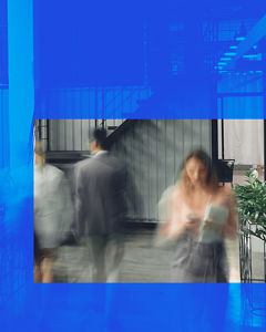 A blurred image of a woman on her mobile phone