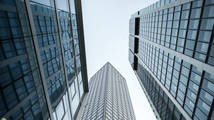 A vertical low angle shot of high rise skyscrapers in a glass facade in Frankfurt, Germany