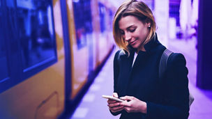 woman looking at phone near train
