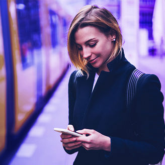 woman looking at phone near train