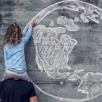 Kind malt Globus an eine Wand