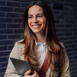 Vrouw met glimlach voor bakstenen muur