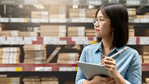 Entrepreneur woman holding smart tablet computer with fulfillment service business warehouse management